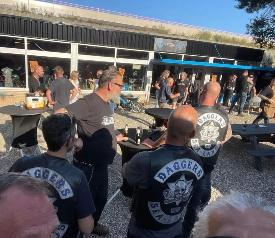 Bezoekers met een drankje voor de shop