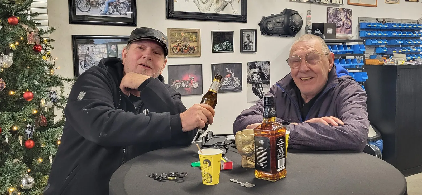 Bezoekers met een drankje tussen de motoren tijdens de oudejaarsborrel in de werkplaats