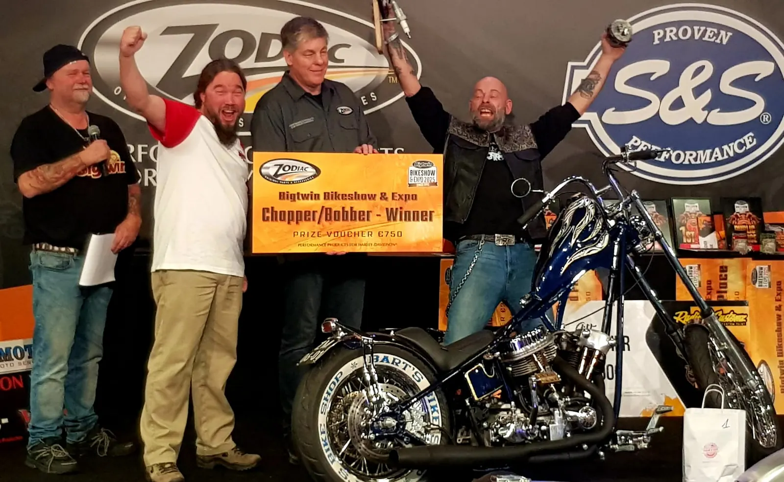 Prijsuitreiking op het Zodiac-podium met het bord Bigtwin Bikeshow en Expo, klasse Chopper/Bobber winnaar